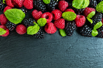 Heap of raspberry and blackberry on stone