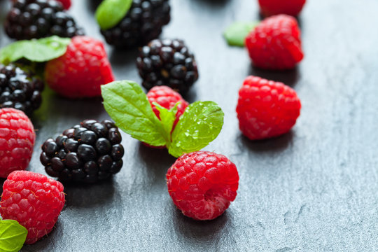 Heap of raspberry and blackberry on stone