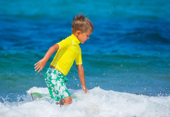 Cute boy surfing