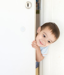 Kid peeking out of the open room door