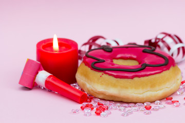 rosa Donut mit brennender Kerze