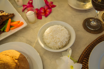 Table with food and drink for romantic dinner on sunset