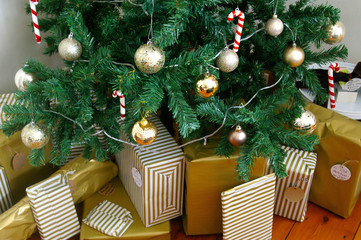 Artificial Christmas tree decorated with presents underneath