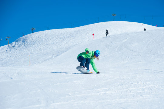 Female snowboarder running down in the mountains. Italian alps, Livigno. Resort Mottolino.