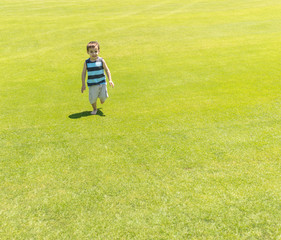 Fototapeta na wymiar Little kid running on green meadow