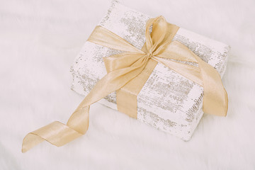 Obraz na płótnie Canvas Shabby chic gift with golden ribbon on white background