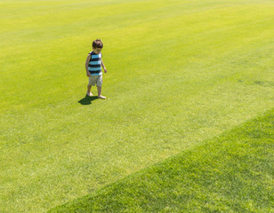 Little kid running on green meadow