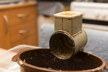 Old grinder with a bowl of nuts