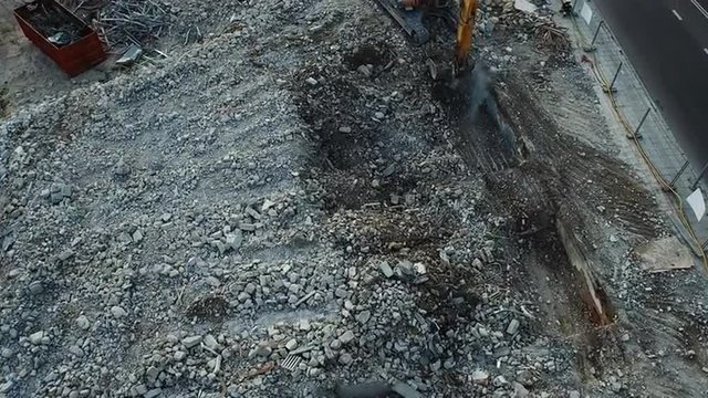 Aerial drone shot of a excavator working in construction yard.