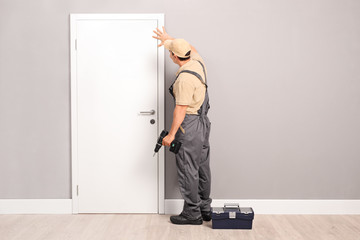 Young handyman installing a door