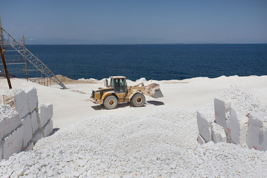 Bulldozer at marble quarry on island