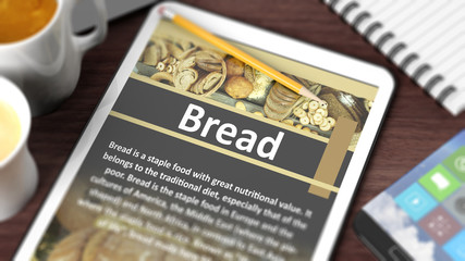 Tabletop with various objects focused on tablet with recipe of "Bread" on screen