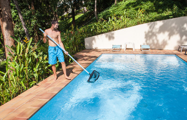 Service . Man cleaning swimming pool . 
