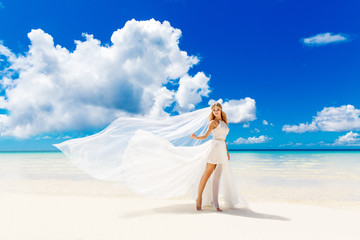 Fototapeta na wymiar Beautiful blond bride in white wedding dress with big long white