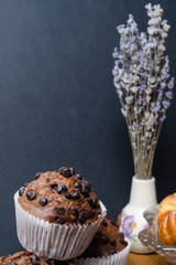 still life of chocolate muffins and a bouquet of lilac flowers
