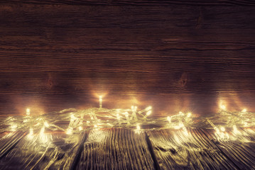 Christmas lights over old wooden background