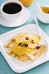 Thin crepes with citrus sauce and dried cranberry