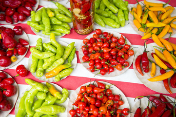 Colorful hot peppers in bright red, yellow, and green piles at farmers market display in Rio de Janeiro, Brazil