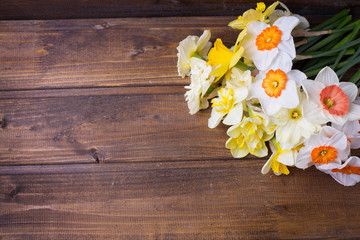 Fresh  spring colorful daffodils  flowers on brown painted woode