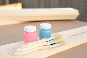 carpenter table with pine wood, paint blue, pink and several brushes
