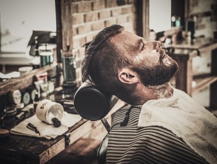 Client during beard shaving in barber shop