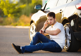 Car and smartphone app concept - man texting sms on phone. Drivi