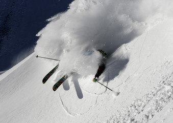 A freeride skier makes a turn in powder snow on a sunny day in western Austria