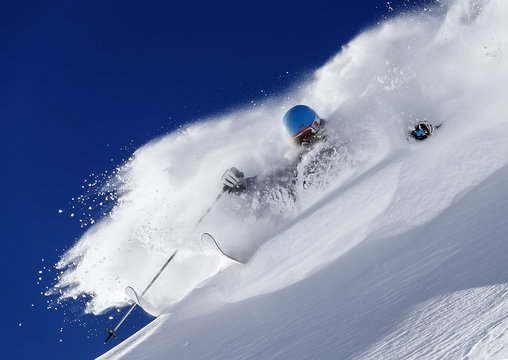 A freeride skier makes a turn in powder snow on a sunny day in western Austria