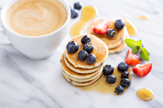 Stack of small pancakes with fresh berries 