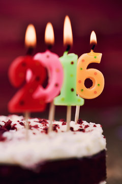lit number-shaped candles forming number 2016 on a cake