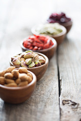 Variety of nuts and dried fruits in small bowls