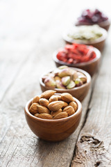 Variety of nuts and dried fruits in small bowls