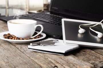 office table with notebook, computer keyboard, mouse, cup of coffee