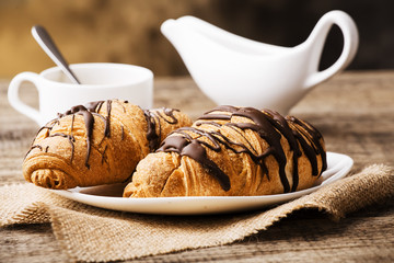 Hot cappuccino and pastries on white wooden boards