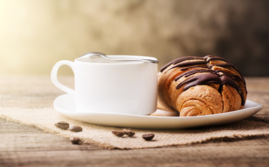 Hot cappuccino and pastries on white wooden boards