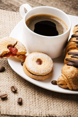 Hot cappuccino and pastries on white wooden boards