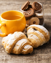 tea and croissant on wooden table