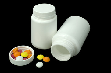 some pills of a different colors with two white jar