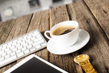 Office concept. Keyboard, tablet pc, and coffee on old wooden ta