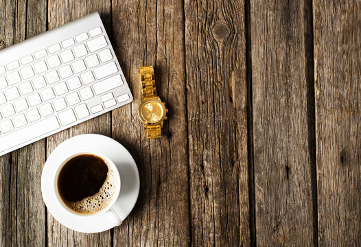 Keyboard, cup of coffee on a wooden background