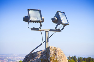 Two projectors of light against a sky background