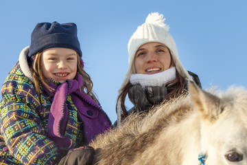 Little girl with horse outdoor in winter