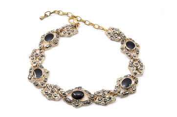 gold bracelet with black stone on a white background