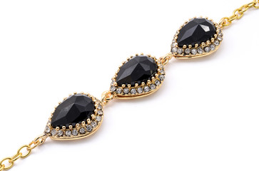 gold bracelet with black stone on a white background