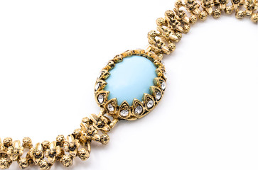 gold bracelet with blue stone on a white background
