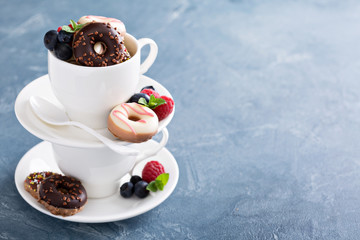 Small mini donuts in stacked coffee cups