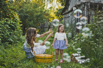 Mom and daughter blowing bubbles outdoors 4711.