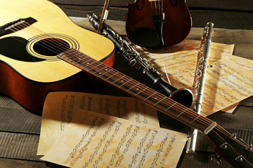 Acoustic guitar, soprano saxophone, violin, flute and note sheets on wooden background © Africa Studio