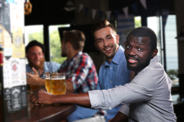 Young men drinking beer in pub