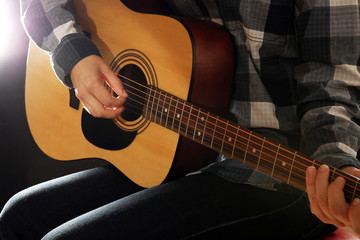 Fototapeta premium Guitarist plays guitar in the studio, close up
